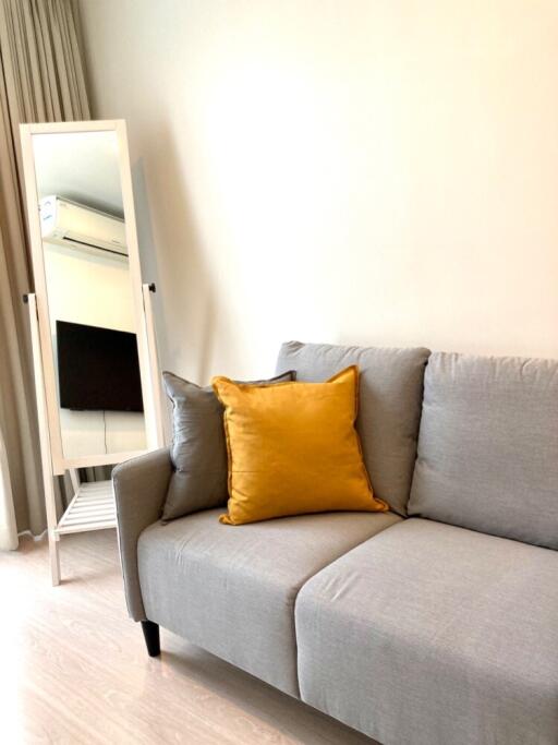 Modern living room with a grey sofa and yellow pillow