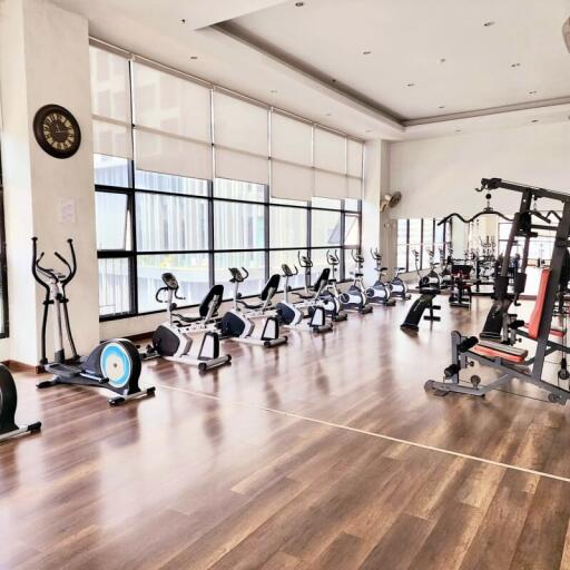 Spacious fitness gym with modern equipment and wooden flooring