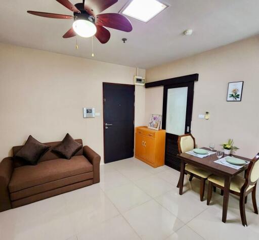 Living room with sofa, dining table, and ceiling fan