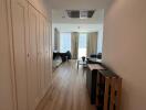 A corridor leading to a living area with wooden flooring and modern furnishings