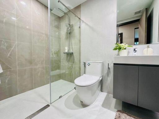 Modern bathroom with glass-enclosed shower, toilet, and vanity