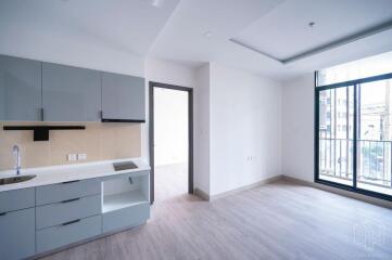 Modern kitchen and living area with gray cabinets and large windows