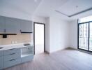 Modern kitchen and living area with gray cabinets and large windows