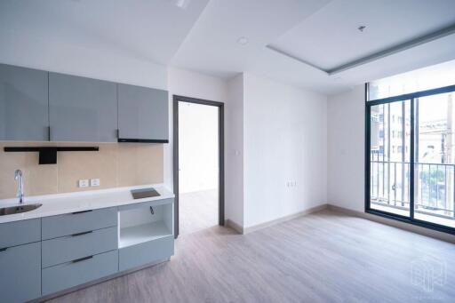 Modern kitchen and living area with gray cabinets and large windows