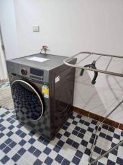 Laundry area with washing machine and drying rack