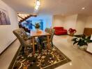 Dining area with table and chairs, staircase, and living space