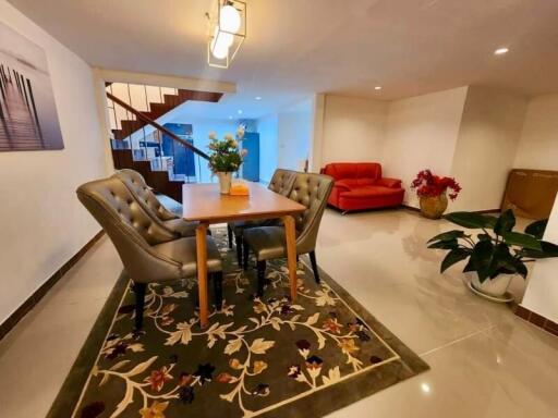 Dining area with table and chairs, staircase, and living space