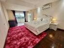 Bedroom with a double bed, red carpet, and air conditioning