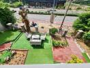 Outdoor garden with seating area, artificial turf, and plants