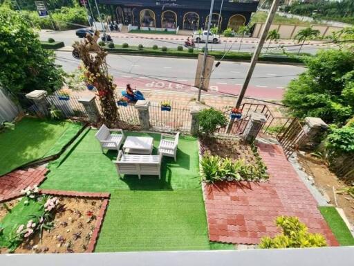 Outdoor garden with seating area, artificial turf, and plants