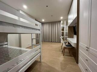 Modern bedroom with bunk bed, built-in wardrobe, and study area