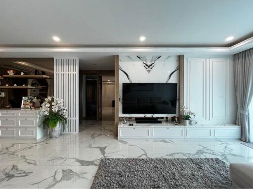 Modern living room with large TV and marble floor