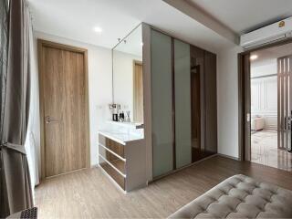 Modern bedroom with wooden door, large wardrobe, and vanity area