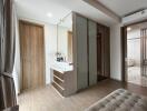 Modern bedroom with wooden door, large wardrobe, and vanity area