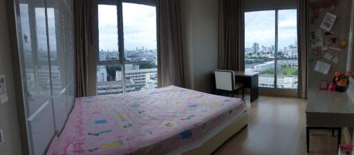 Spacious bedroom with large windows and city view