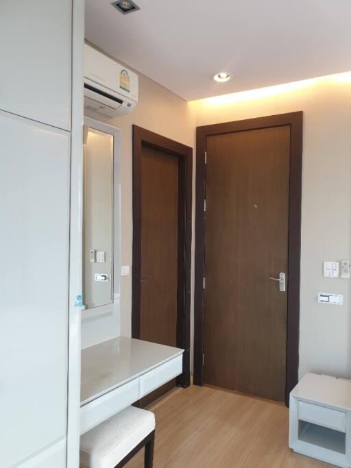 Bedroom with dresser, air conditioning, and wooden flooring