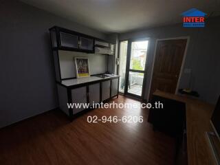 Small kitchen with wooden flooring and a balcony door