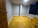 Empty bedroom with parquet flooring and small table