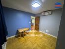 Empty room with wooden floor, small wooden table, and blue-gray walls