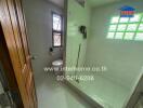 Modern bathroom with shower area, window, and towel rack