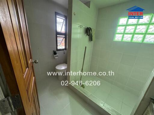 Modern bathroom with shower area, window, and towel rack