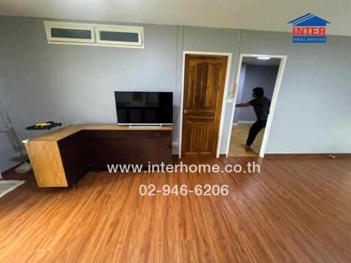 Living room with wooden flooring and TV on stand