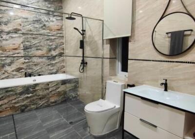 Modern bathroom with bathtub, shower, toilet, and sink