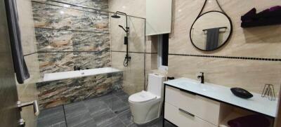 Modern bathroom with bathtub, shower, toilet, and sink