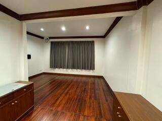 Spacious living room with wooden floors and recessed lighting