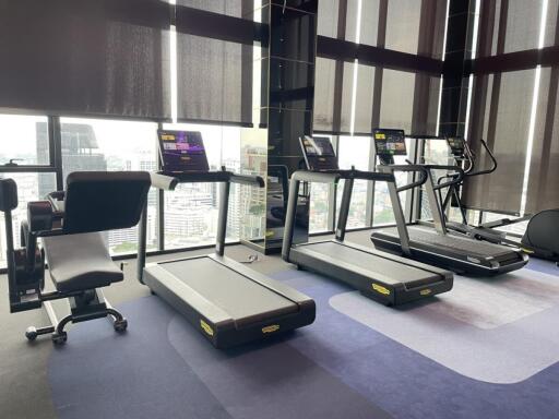 Well-equipped gym with treadmills and city view