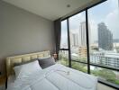 Bedroom with a large window and city view