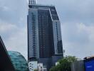 Modern high-rise building with adjacent pedestrian area