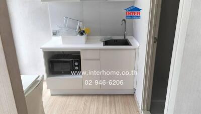 compact modern kitchen with white cabinets and appliances