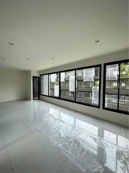 Spacious living room with large windows and tiled floor