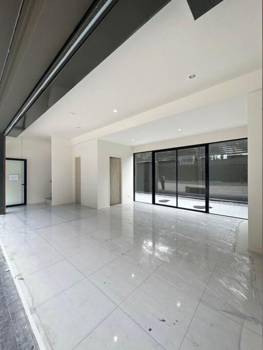 Spacious, modern living area with large windows and tiled floor