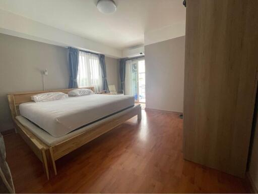 Modern bedroom with wooden flooring and a large bed