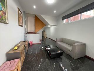 Modern living room with gray sofa, coffee table, and black marble flooring