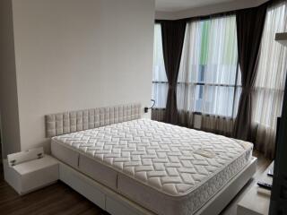 Bedroom with large mattress and floor-to-ceiling windows