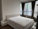 Bedroom with large mattress and floor-to-ceiling windows