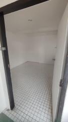 Empty white tiled room with a door