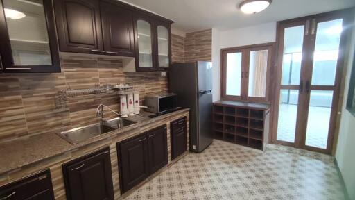 Modern kitchen with dark wooden cabinets and granite countertops