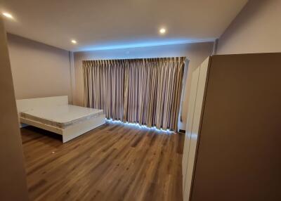 Spacious bedroom with hardwood floors and modern lighting