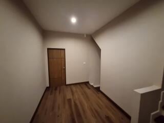 Empty room with wooden floor and a closed door