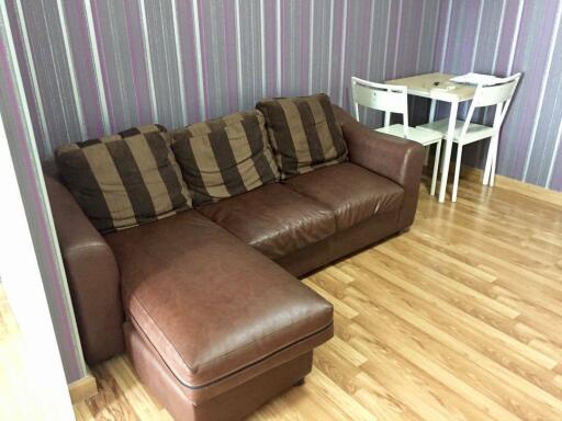 Living room with brown sectional sofa and small dining table