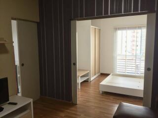 Modern bedroom with wooden flooring and large window