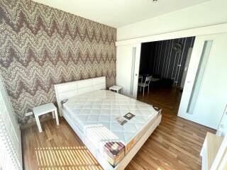 A spacious bedroom with wooden flooring