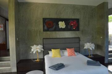 Modern bedroom with king-size bed and decorative painting