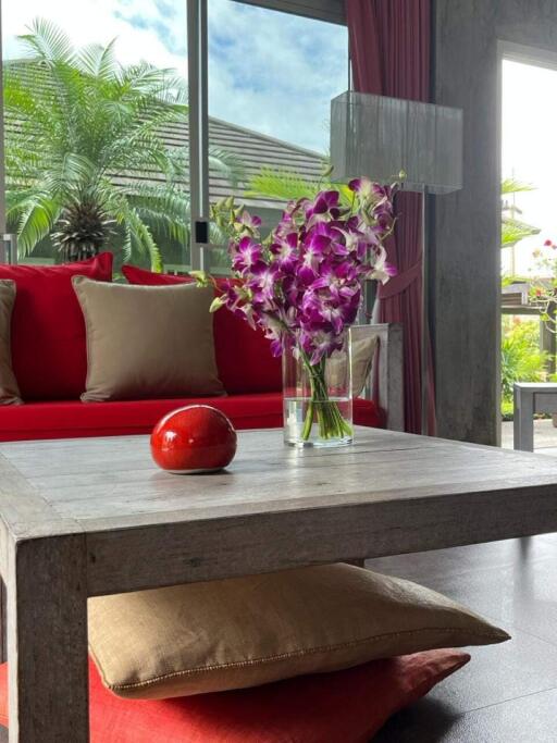 Modern living room with red cushions and floral centerpiece