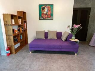 Living room with purple sofa and bookshelf