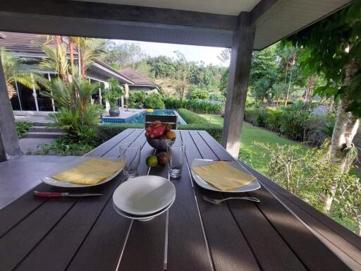 Outdoor dining table with view of the garden and pool